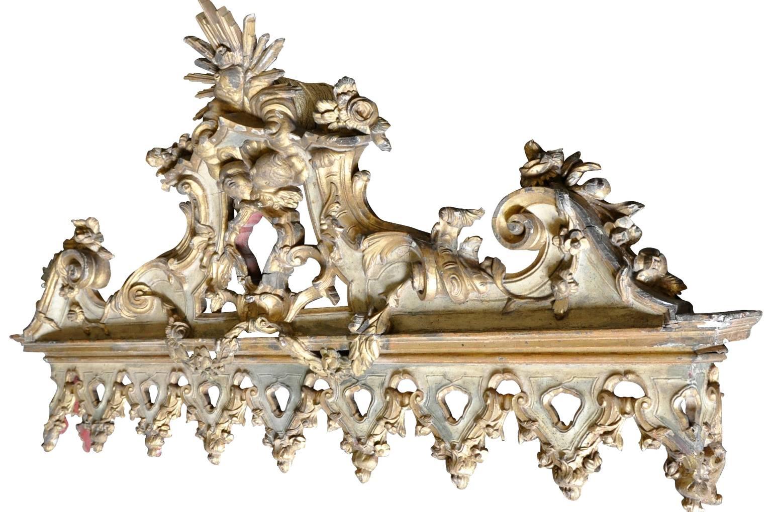 A sensational 18th century architectural fragment - pediment in polychromed and giltwood. Decorated with two charming putti, a sacred heart and sunburst. This wonderful piece origins from a hotel in Portugal. It will serve beautifully incorporated