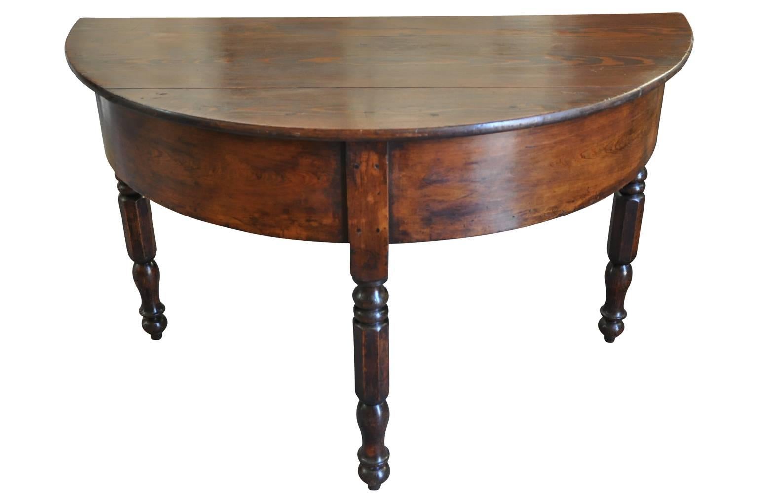 A very handsome early 19th century demilune console table from the Catalan region of Spain. Beautifully constructed in richly stained pine with a deep apron and nicely turned legs.