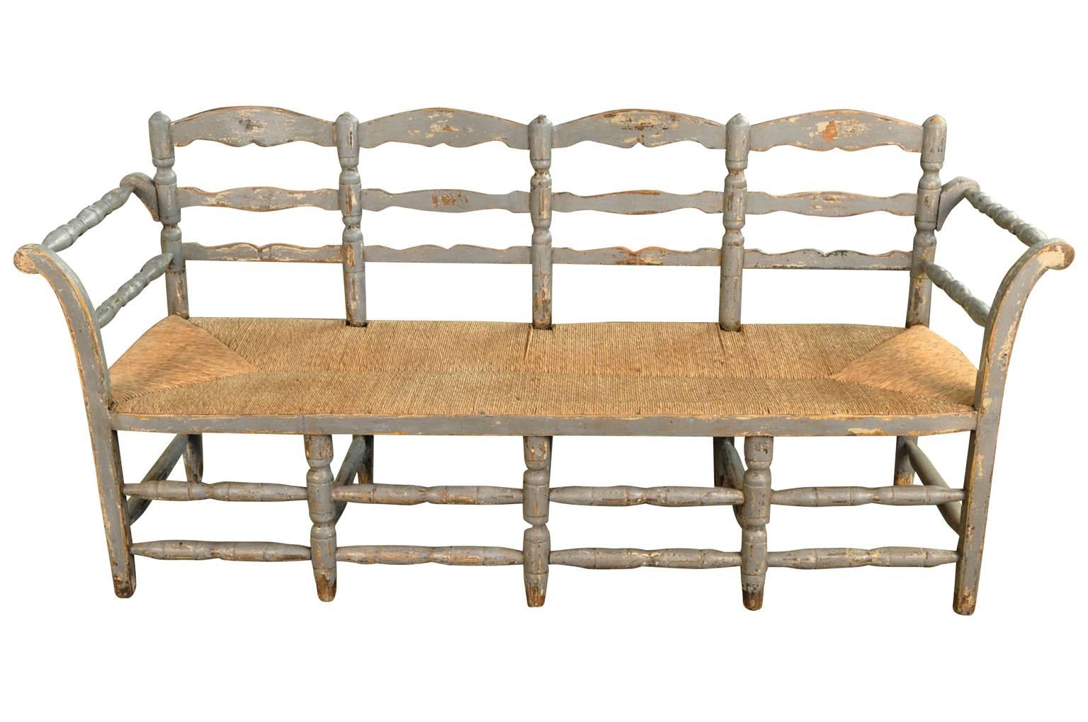 A very charming mid-19th century painted wood bench from Portugal. Wonderful patina and finish with a handsome rush seat.