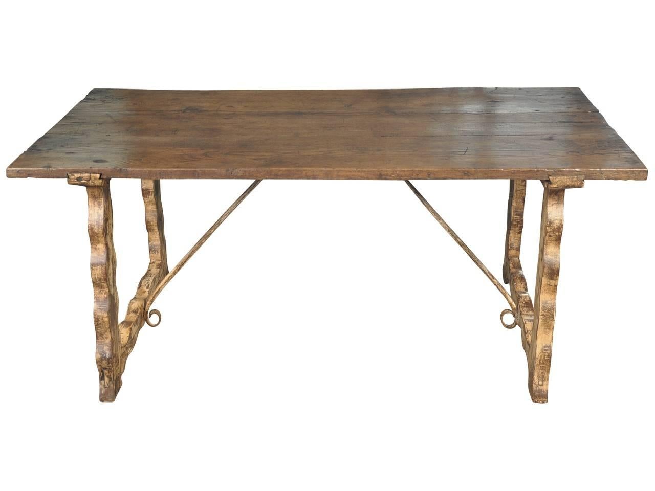 A charming and primitive farm table from Portugal. Soundly constructed from chestnut with iron stretchers. The classical lyre shaped legs and stretchers have a scraped painted finish. A wonderful piece as a breakfast table, small dining table or
