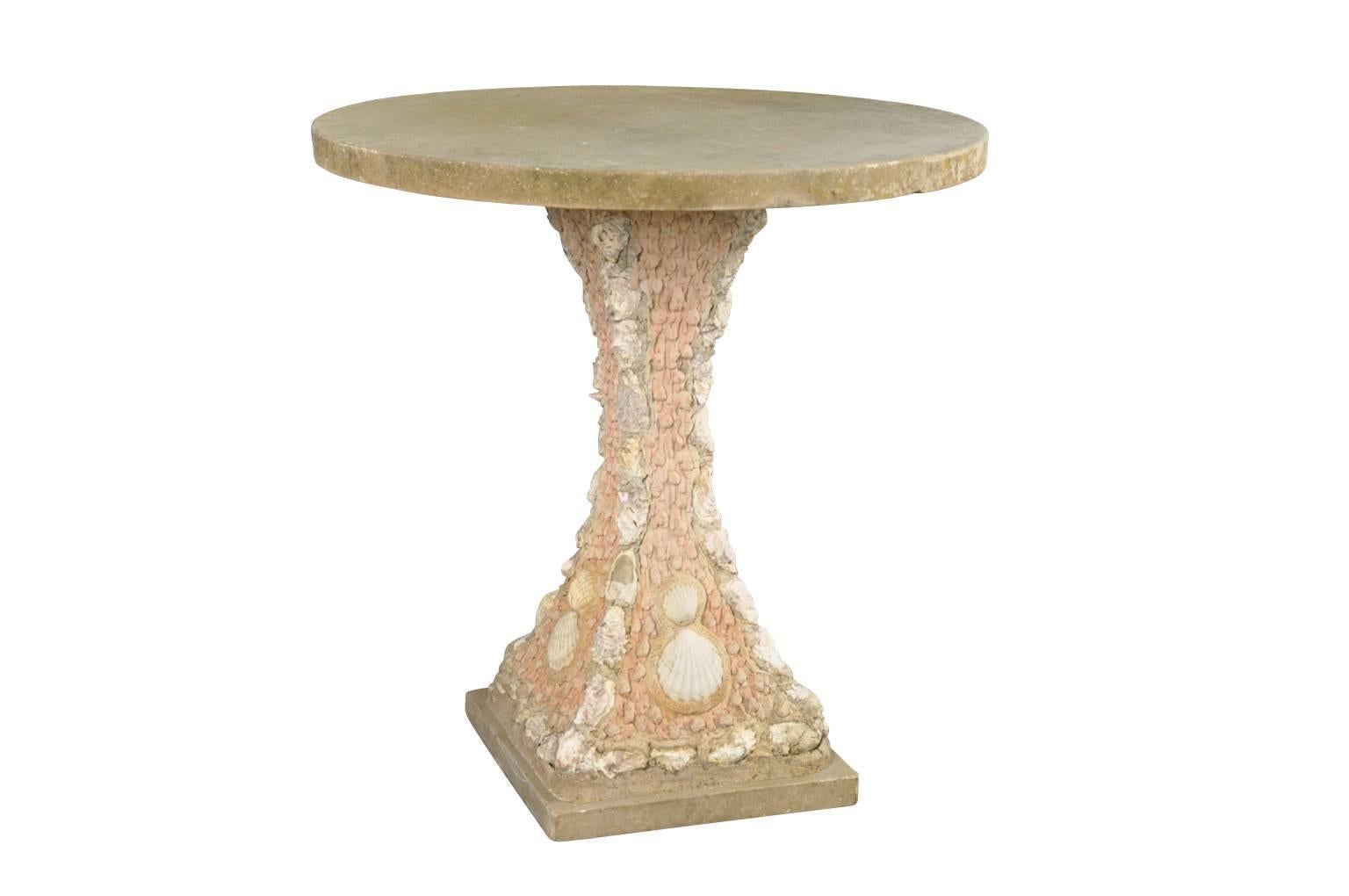 A sensational vintage French garden table with a shell motif. Wonderfully constructed with a coade stone base decorated with sea shells and a stone top. A terrific piece for any garden or interior.