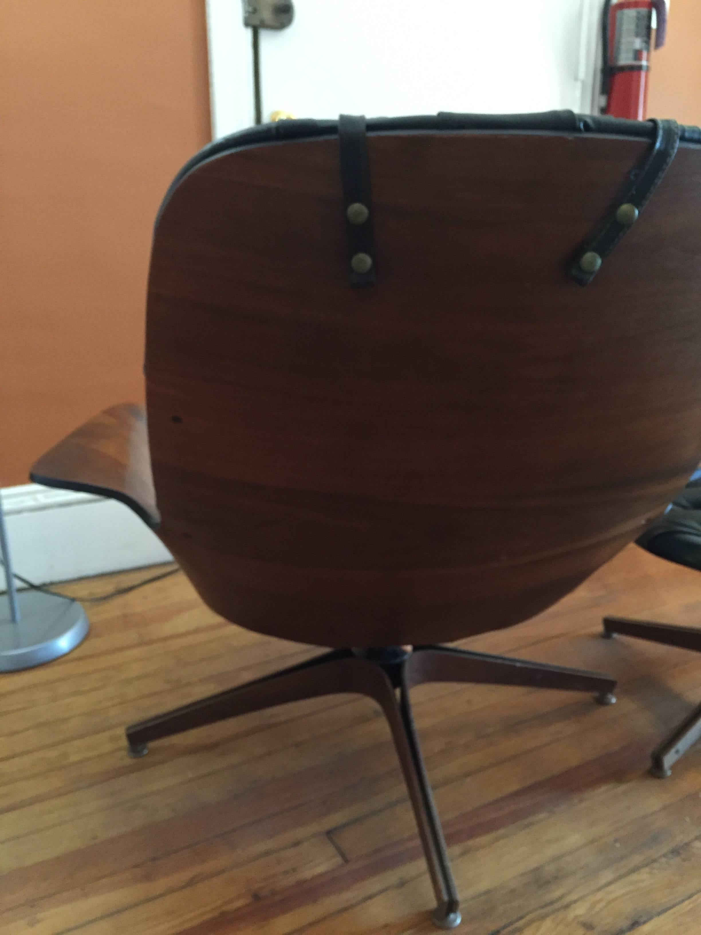 Designed in the 1950s by George Mulhauser of the Plycraft Company, one of the first and the best makers of molded plywood furniture, along with Herman Miller.
Attractive walnut bentwood arms and back.   Black naugahyde upholstery on both chair and