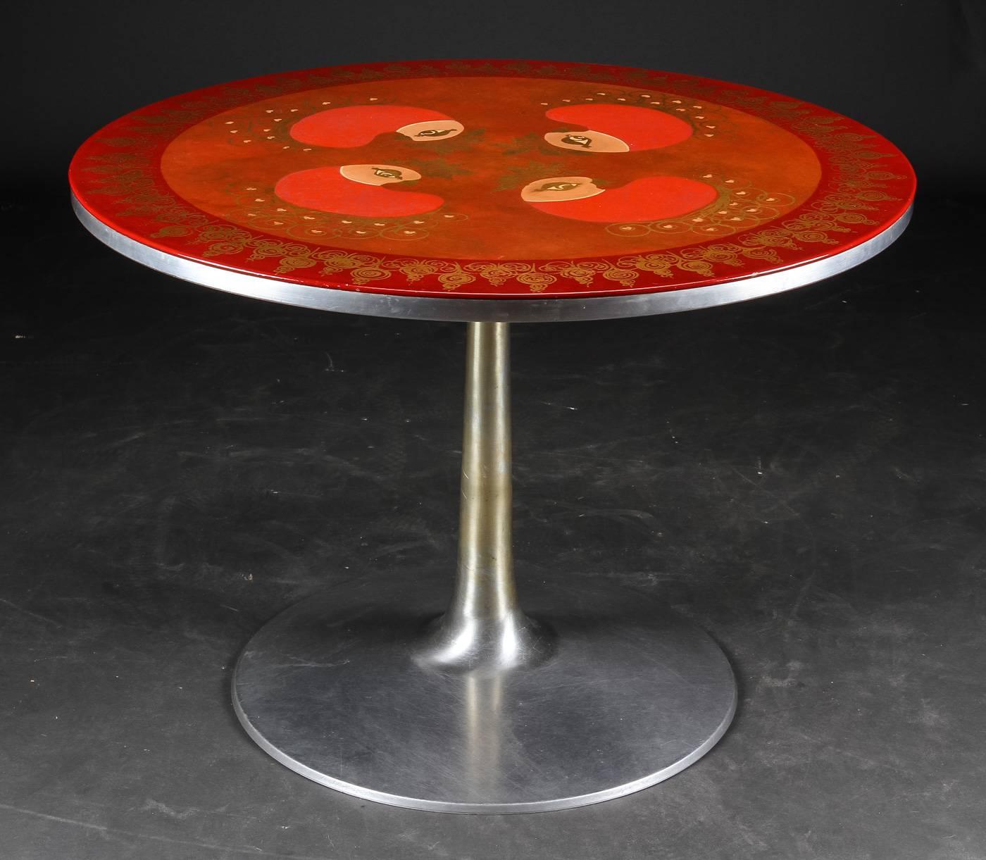 Elegant circular dining table of trumpet aluminum, adorned with intricately hand-painted bird motif with reds, oranges and gold filigree by Susanne Fjeldsøe “Mygge” (Signed "Mygge").
