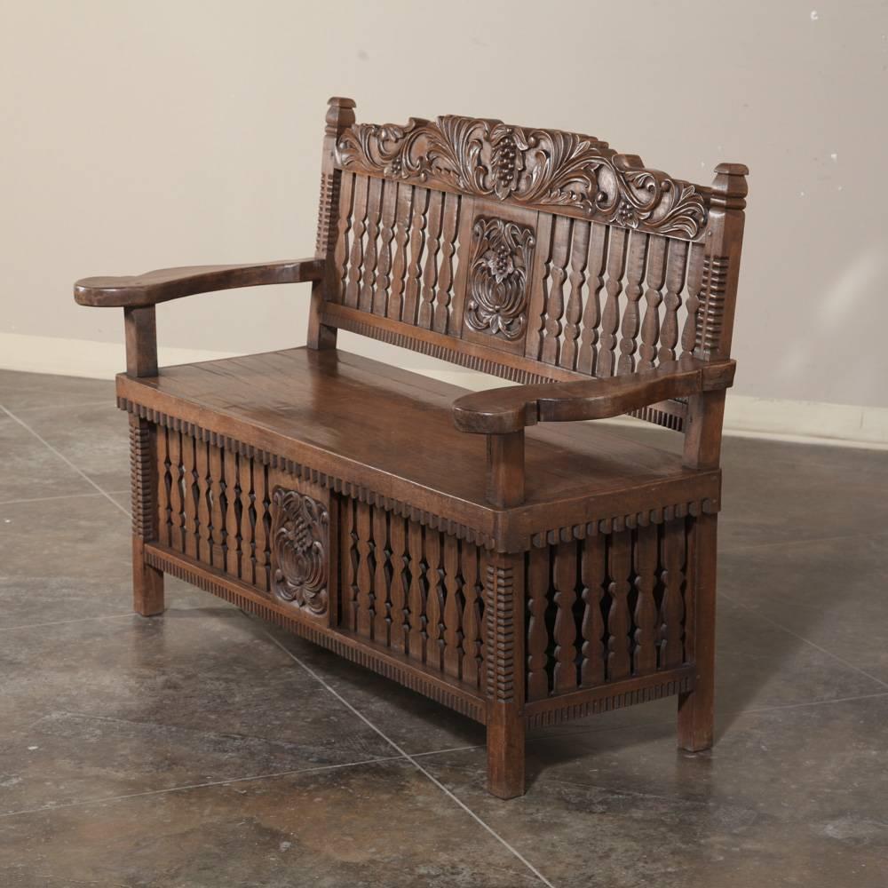 This charming 19th century country French hall bench features a spacious seat with armrests, plus carved embellishment depicting grape clusters and lavish foliates. Slatted seat back and lower section provide unique visual appeal,
circa