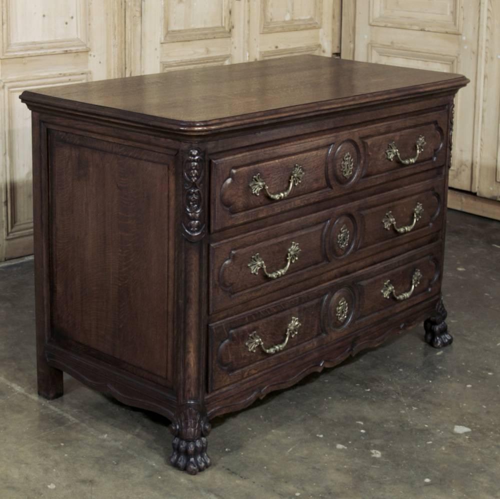 Perfect for the masculine decor, this Antique French Louis XIV Commode was hand-crafted from solid old-growth oak, and features finely carved cornerposts with lion's paw feet in contrast to the simply molded drawer facades.  Exquisite cast bronze