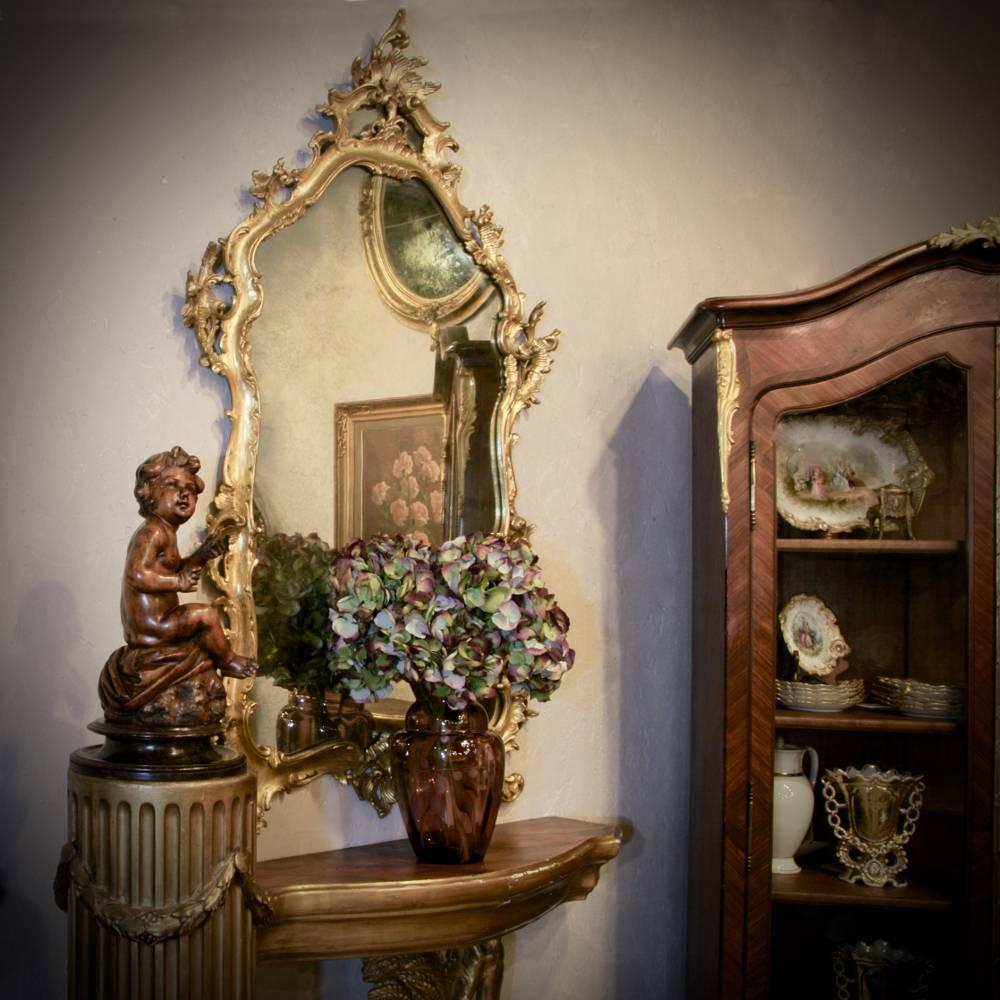 Sculpted from solid wood by master Italian artists, this stunning 19th century giltwood Italian Rococo mirror represents the essence of the naturalistic form, accentuated by the opulence of the patinaed gold coloration and depicting a fine example
