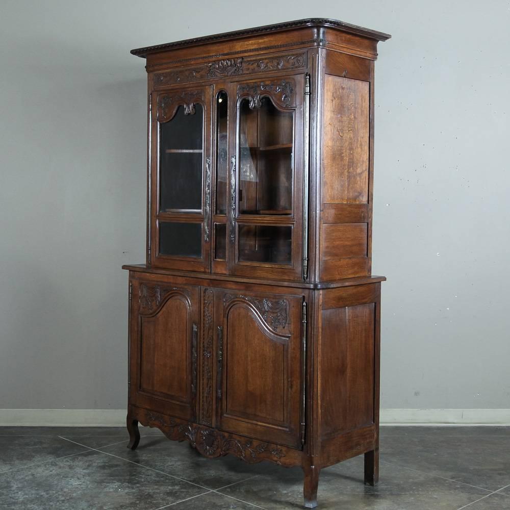 This charming and magnificent 18th Century French Buffet a Deux Corps from Normandie was meticulously hand-carved from indigenous old-growth quarter-sawn white oak and will make an excellent choice as a bookcase or display case as well!  Charming