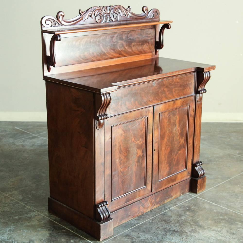 The sheer natural beauty of the exotic imported mahogany has been allowed to take center stage with this incredibly well-preserved 19th century French Louis Philippe buffet/secretaire! The backsplash with shelf prevents surface items from slipping