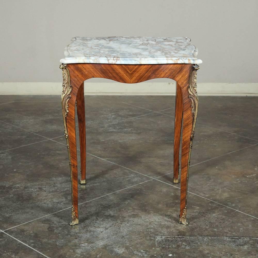 This 19th century French marble-top end table was crafted in Transitional Louis XV style with subtly scrolled legs, oriented-grain mahogany veneer, and bronze ormolu mounts, all topped off with beautifully veined contoured and beveled marble,
circa