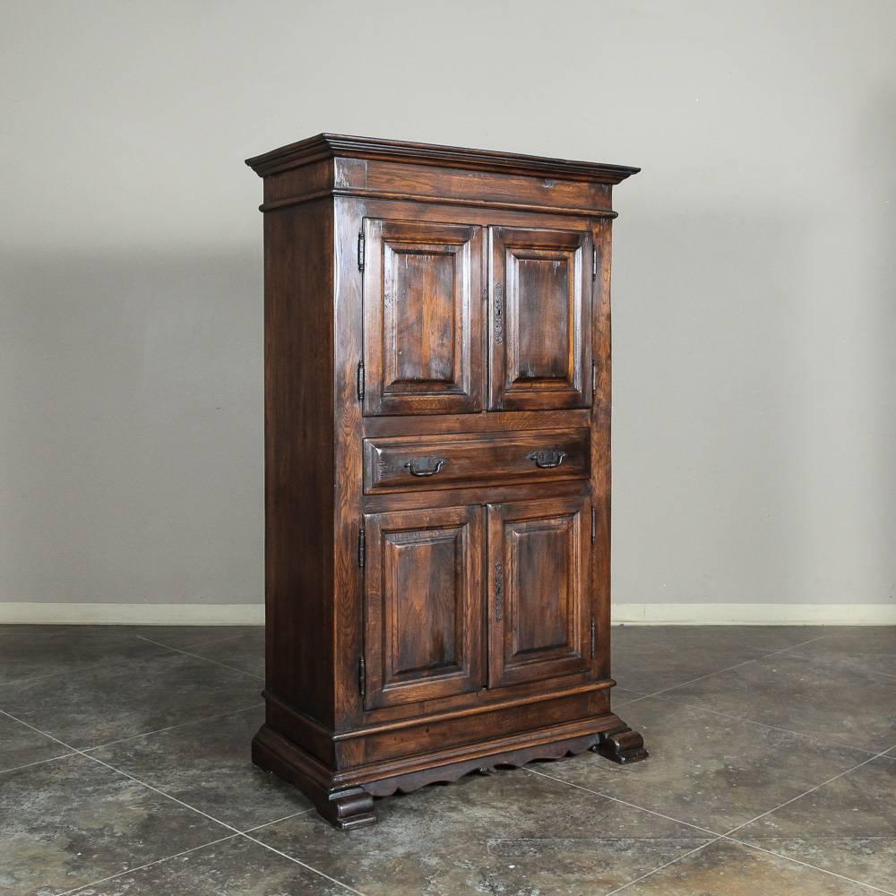 Called an Homme DeBout by the French, which is the masculine counterpart to the Bonnetiere, this handsome 19th century Rustic Dutch cabinet features a cabinet above and below separated by a full width drawer. Crafted from dense, old-growth oak to