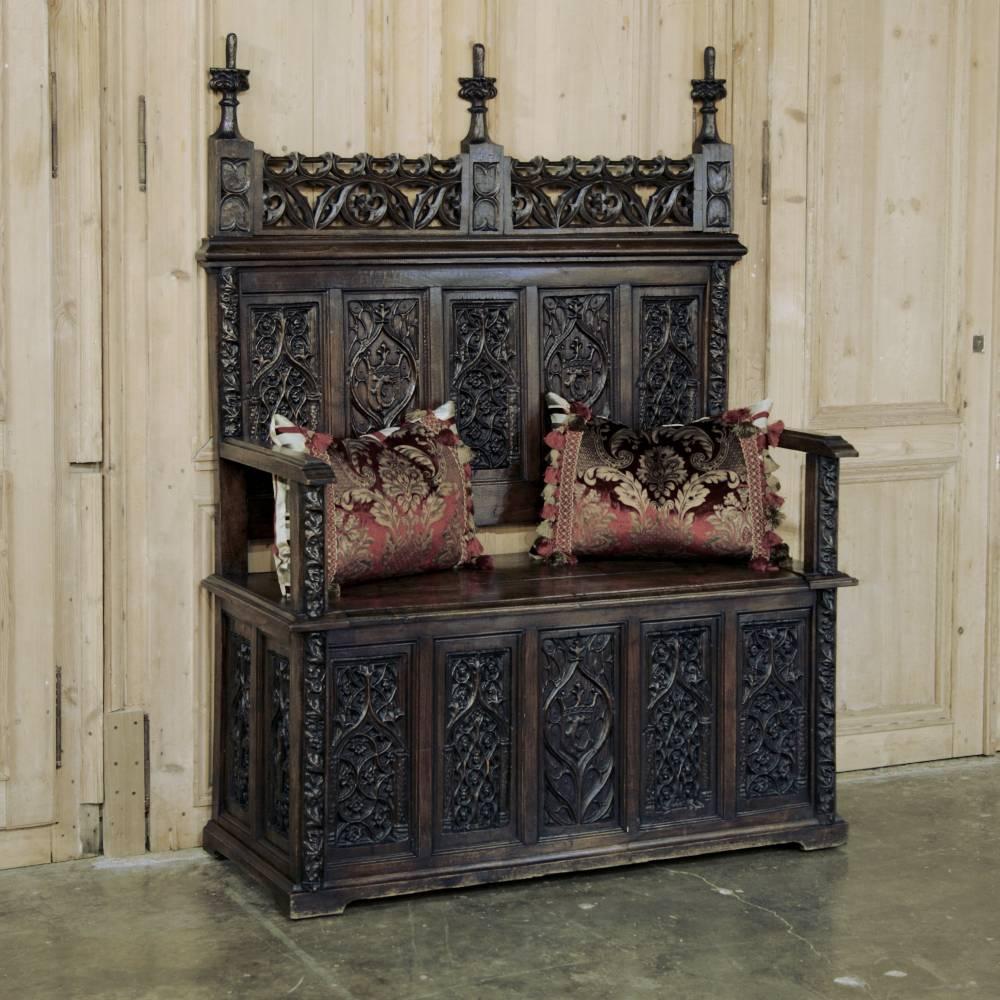 This 19th century French Gothic hall bench is a spectacular display of the sculptor's art, with every face above and below and on each sides carved with an amazing plethora of geometric designs framed by Moorish arches. Seat opens to reveal trunk