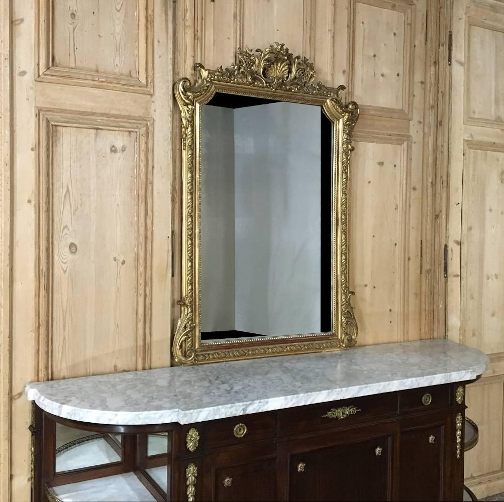 This timeless 19th century French Regence gilded mirror features stunning detail around the entire framework, with special attention paid to the crown! The elaborate detail was designed to command one's attention immediately upon walking into the