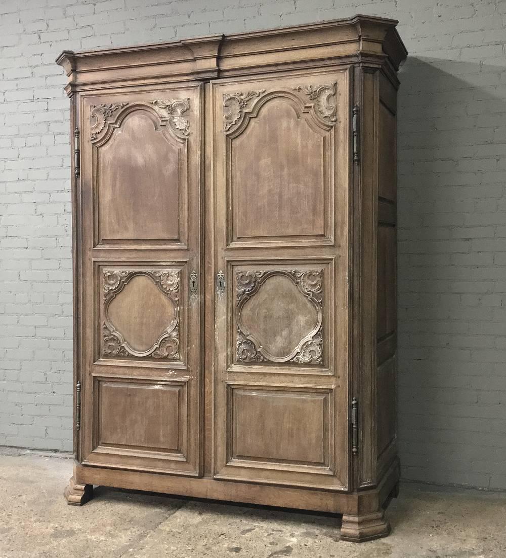 This spectacular 18th century French Louis XIV armoire has been created on a large scale and masterfully handcrafted from old-growth quarter-sawn oak to last for generations! Bold molding on the crown appears over the beautifully sculpted doors