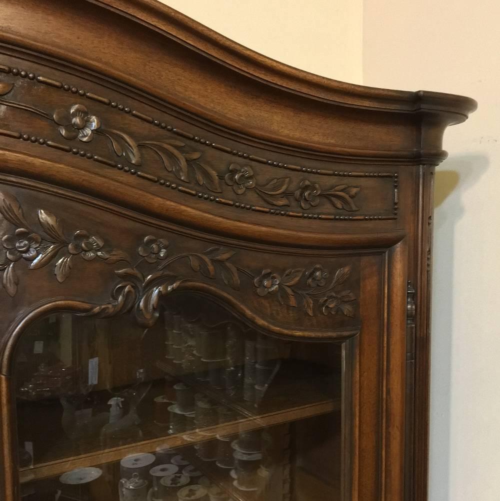 19th century country French neoclassical walnut buffet a Deux Corps serves equally as well as a Bookcase and features classical embellishment hand-carved into the sumptuous French walnut with the added grace of curvaceous French scrolled designs in