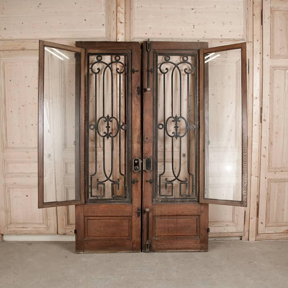 Pair of grand stunning antique French doors with heavy riveted hand-forged wrought iron in a solid oak raised panel frame.
Measures: 96.5 H x 60 W,
circa 1890.