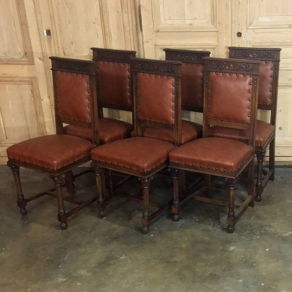 This amazing set of twelve Italian neoclassical walnut chairs were artfully sculpted from fine Italian walnut in the Romanesque manner and feature tapered and fluted column legs, lavish seatback crowns adorned with foliates in full relief and a
