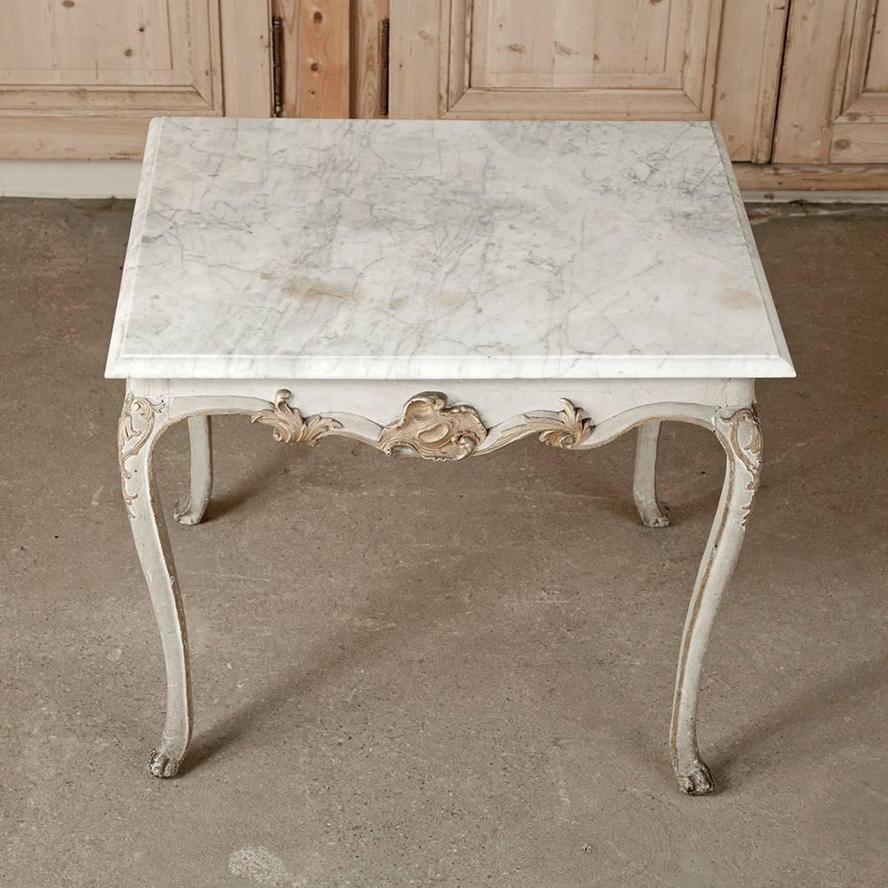 18th Century French Period Painted and Gilded Carrera Marble Top Table. The elegant details on this Louis XV style French table have been highlighted by the hand-applied antique gilding and original painted detailing by the artisan over 260 years