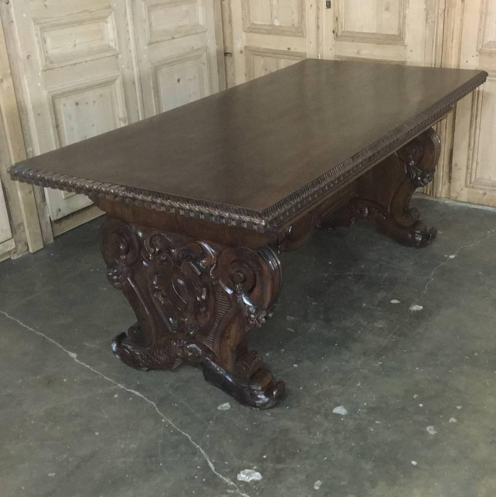 Sculpted by master artisans, this exquisite antique Italian walnut baroque table will serve just as brilliantly as an executive desk! Dolphins' heads appear on each of the four feet, leading the eye up the boldly scrolled legwork festooned with