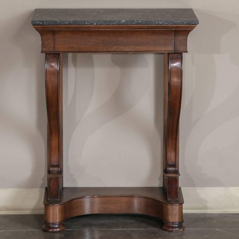 Pleasing to the eye due to its elegance of form and tailored architecture, this 19th century French Louis Philippe marble top console represents the essence of the genre, with gracefully scrolled legs, a concave shelf support below, and a full width