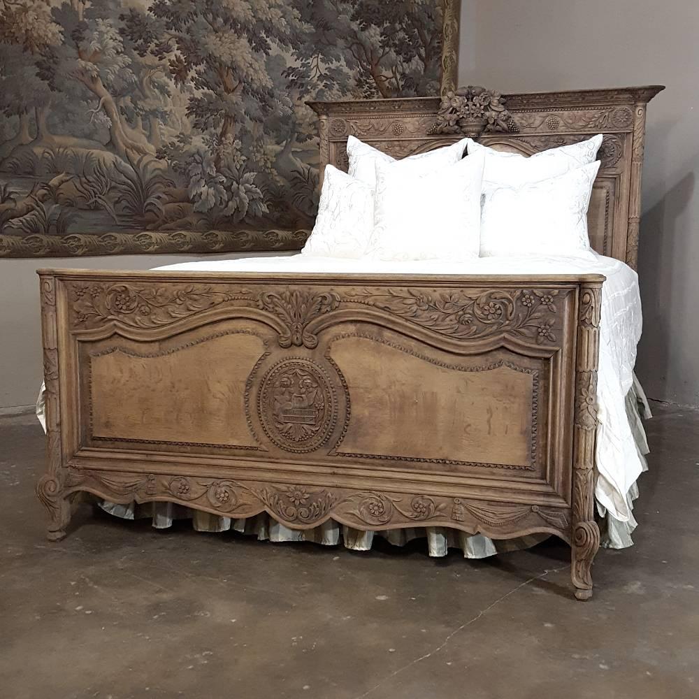 This lovely 19th century Country French Normandie queen bed, fashioned completely by hand from the preferred local indigenous white oak, features hand-carved sculpture across the entire top of the headboard, the footboard, and even the side rails!