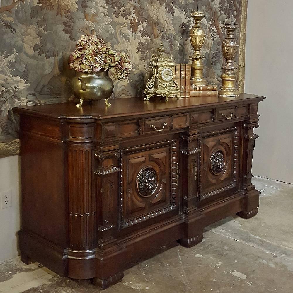 Crafted by master artisans from the finest wood to ever be harvested from the European continent, this impressive 19th century French Louis XIV walnut buffet features boldly sculpted lion's heads appearing at the centre of grandly molded door