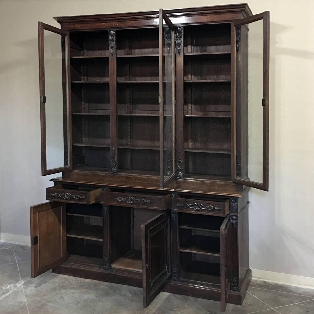 Crafted on a large-scale to impress one's guests, this 19th century Grand Henri II French bookcase will display an enormous amount of books, collectibles or family heirlooms! Rendered from solid old-growth oak, it features subtle, stylized