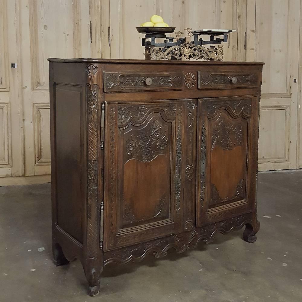 From Normandie, France, comes this amazing 18th century country French buffet, hand-carved to perfection with wildflowers, foliates and wheat, all of which exist in abundance in that fertile region of the country.  Sculpted from solid, well-seasoned