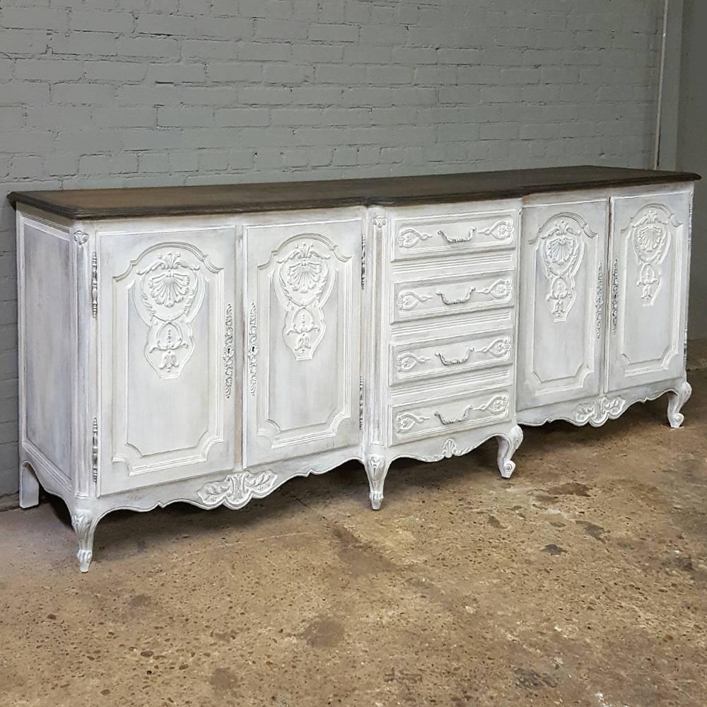 This impressive antique country French grand painted buffet features a step-front center section with four vertically arranged drawers, which perfectly complement the four cabinets flanking it. Contrasting top follows the casework contour, and the