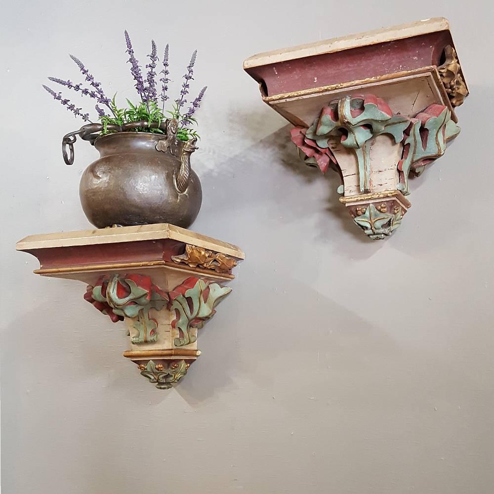 This impressive Large Pair of Carved French Wood Hand-Painted Gothic Shelves Sconces boast a antique painted finish that has achieved a lovely patina over the past century. Crafted in France of the oldest style from historic Western Europe design,