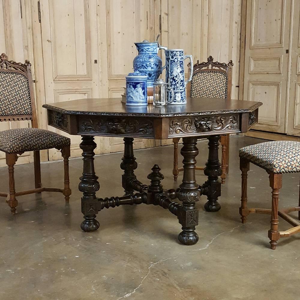 Handcrafted from solid old-growth quarter-sawn oak, this handsome 19th century French Renaissance octagonal game table boasts four drawers concealed within the eight facades, all of which are hand-carved to perfection with flora and fauna motifs.