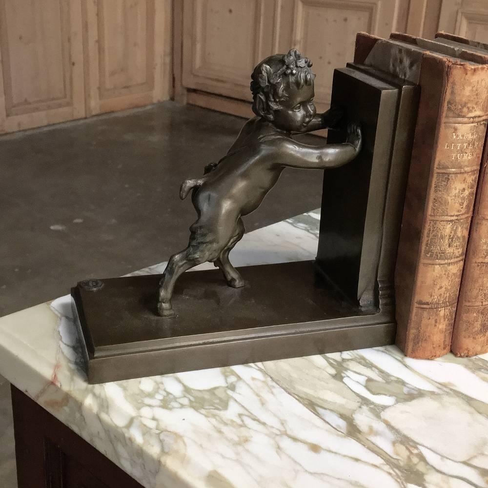 Cast in solid bronze in Paris and stamped guaranteed as such by the Parisienne Registry, this charming pair of 19th century bronze bookends depict a young pan and goat appearing to be pushing against each other, succeeding in holding up the books in