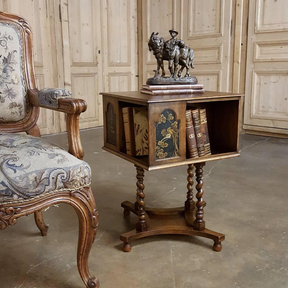 This intriguing antique swivelling bookcase end table is a marvel of craftsmanship and functionality! Handcrafted from fruitwood, it features a boxlike top which is decorated with two painted scenes, repeated on the opposite sides. The top swivels,