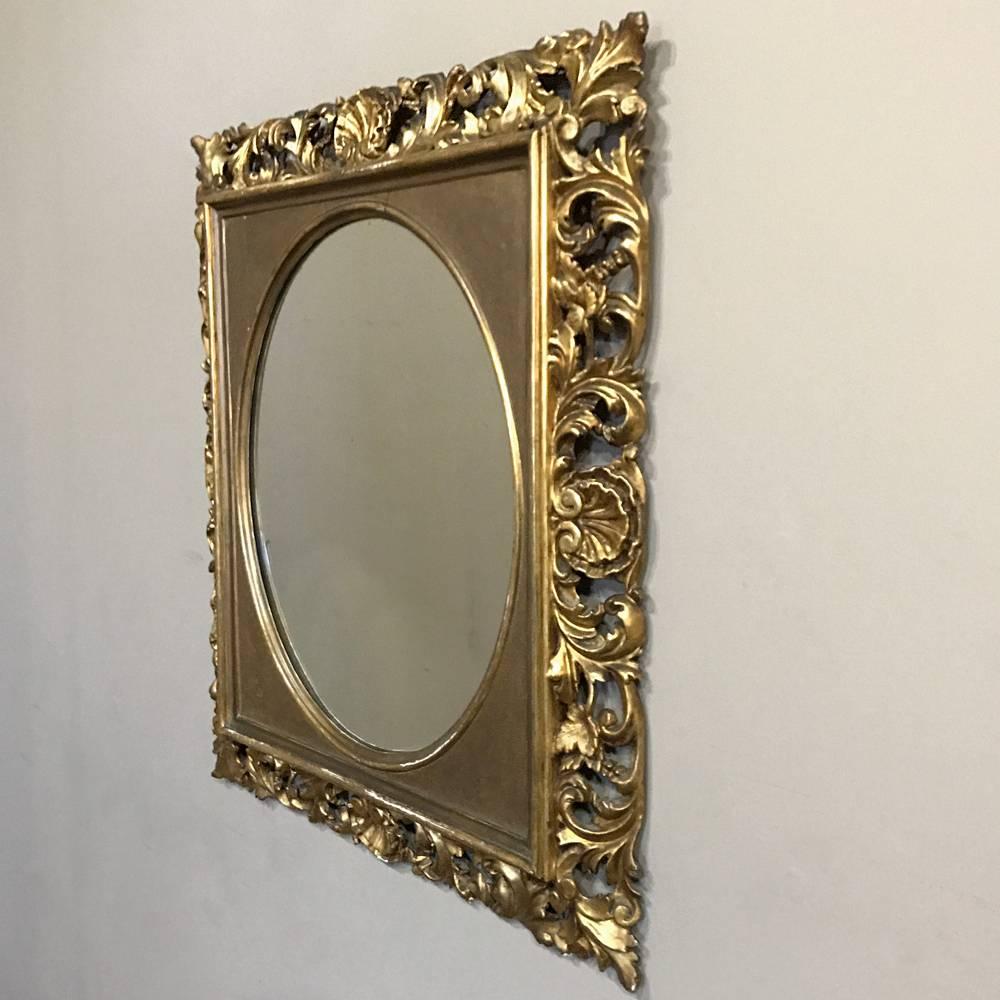 This 19th century French Baroque hand-carved giltwood mirror is a wonderful testament to the talented artisans who created it. Combining a rectangular frame coupled with an oval mirror for a unique look, it was created by hand-carving the wood frame