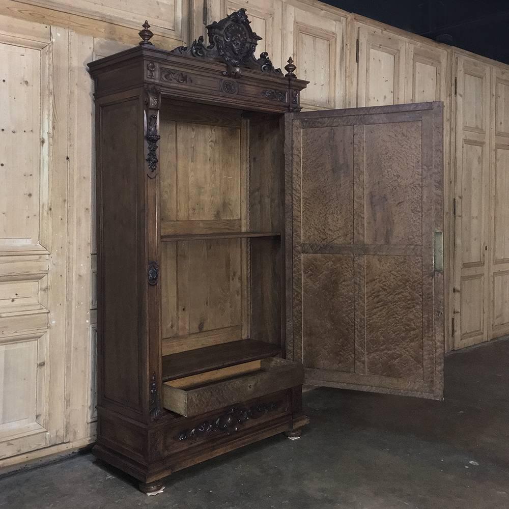 Sculpted with amazing detail from solid French walnut, this impressive 19th century Napoleon III Period armoire features an angel and laurel garlands on a crest as the centrepiece of the crown. Flanked by finials, the crown is situated above the