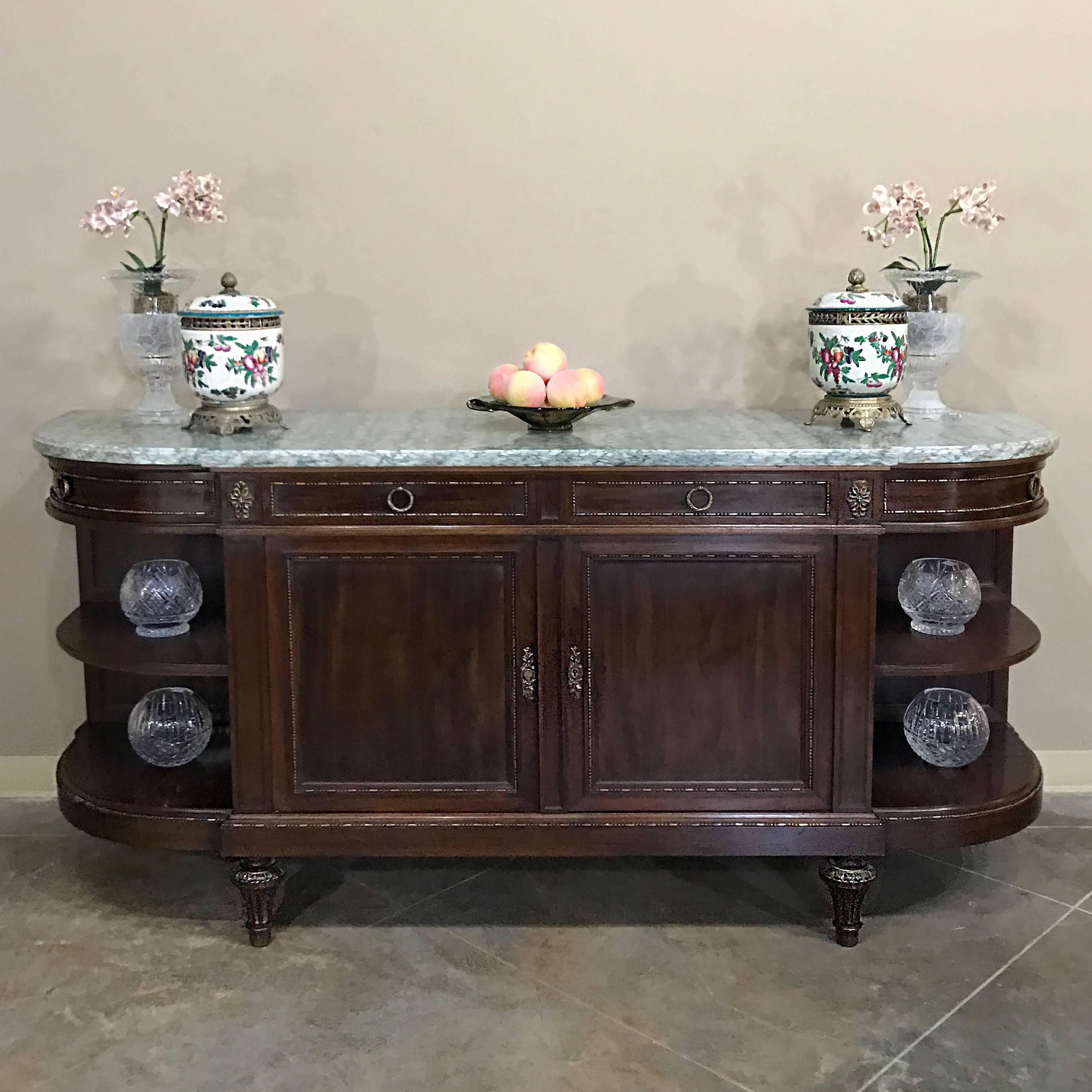 19th century French neoclassical mahogany marble top buffet features rounded sides with open display shelves so that you can display, serve and store in style,
circa 1890s
Measures: 38 H x 79 W x 22 D.