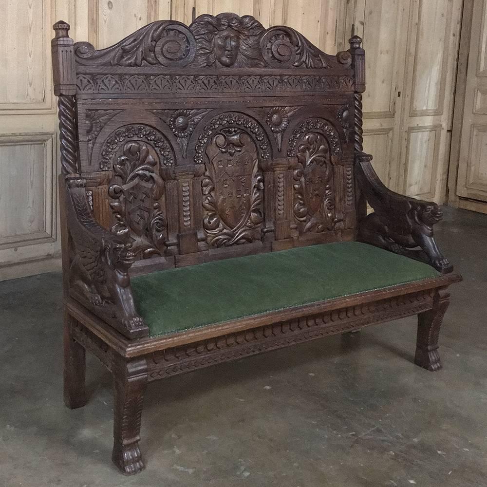 19th century hand-carved German Renaissance hall bench is a spectacular example of fine craftsmanship at the peak of its popularity during the Renaissance Revival of the mid-19th century! Family crests are immortalized in the wood, expertly and