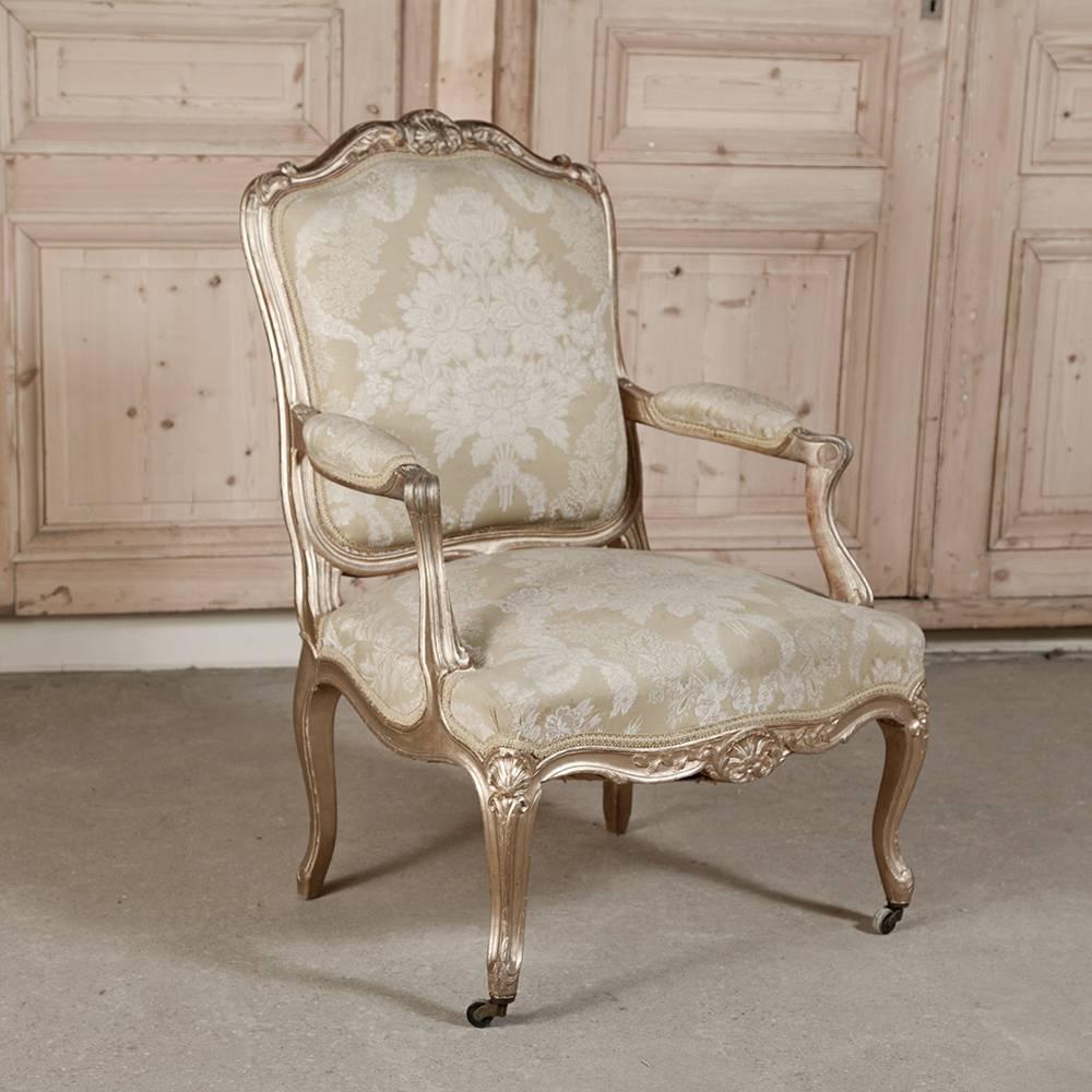 Absolutely fantastic pair of 19th century large-scale antique Italian hand-carved giltwood Rococo armchairs lavished with damask fabric on sculpted Louis XV-inspired frames with gilded finish. The opulent Italian Rococo design style has influenced