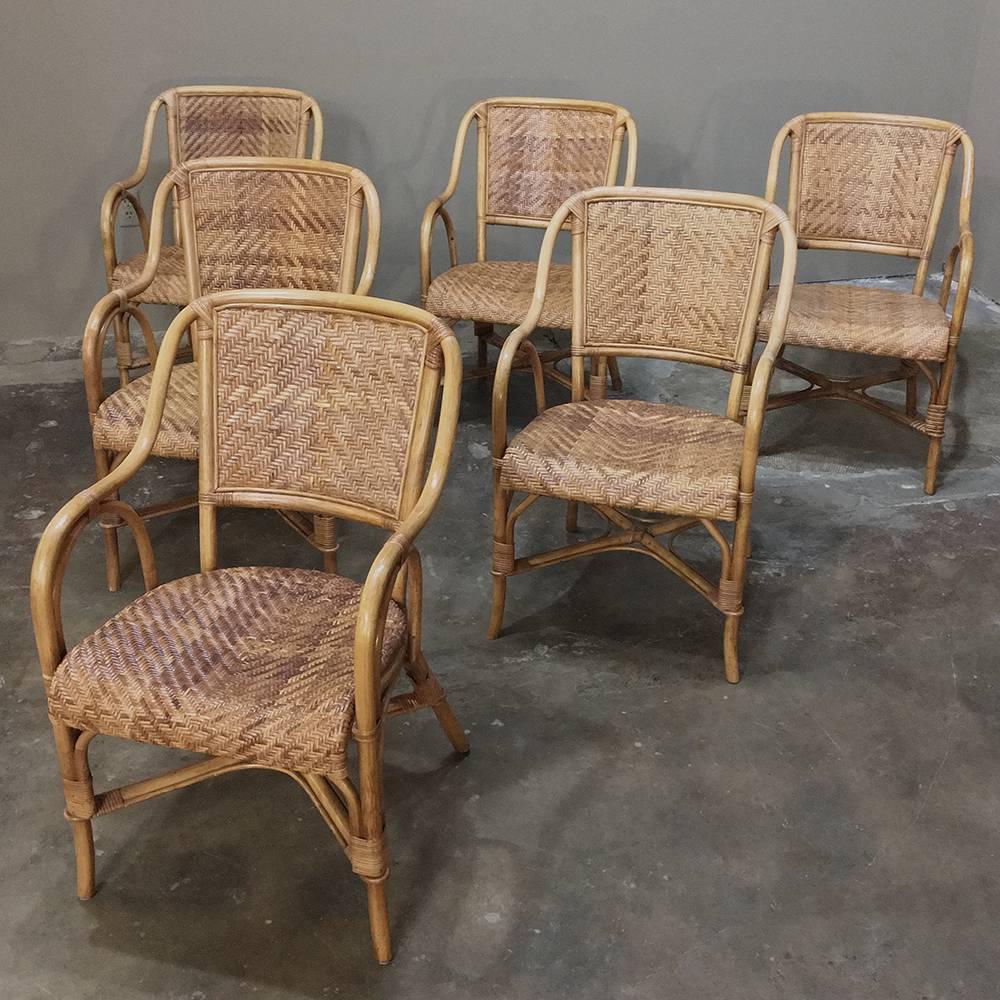 Set of six Mid-Century rattan and bamboo dining armchairs are ideal for use on the porch or patio and their light weight makes them a cinch to move indoors during inclement weather. The breathability of the caned construction of these chairs keeps
