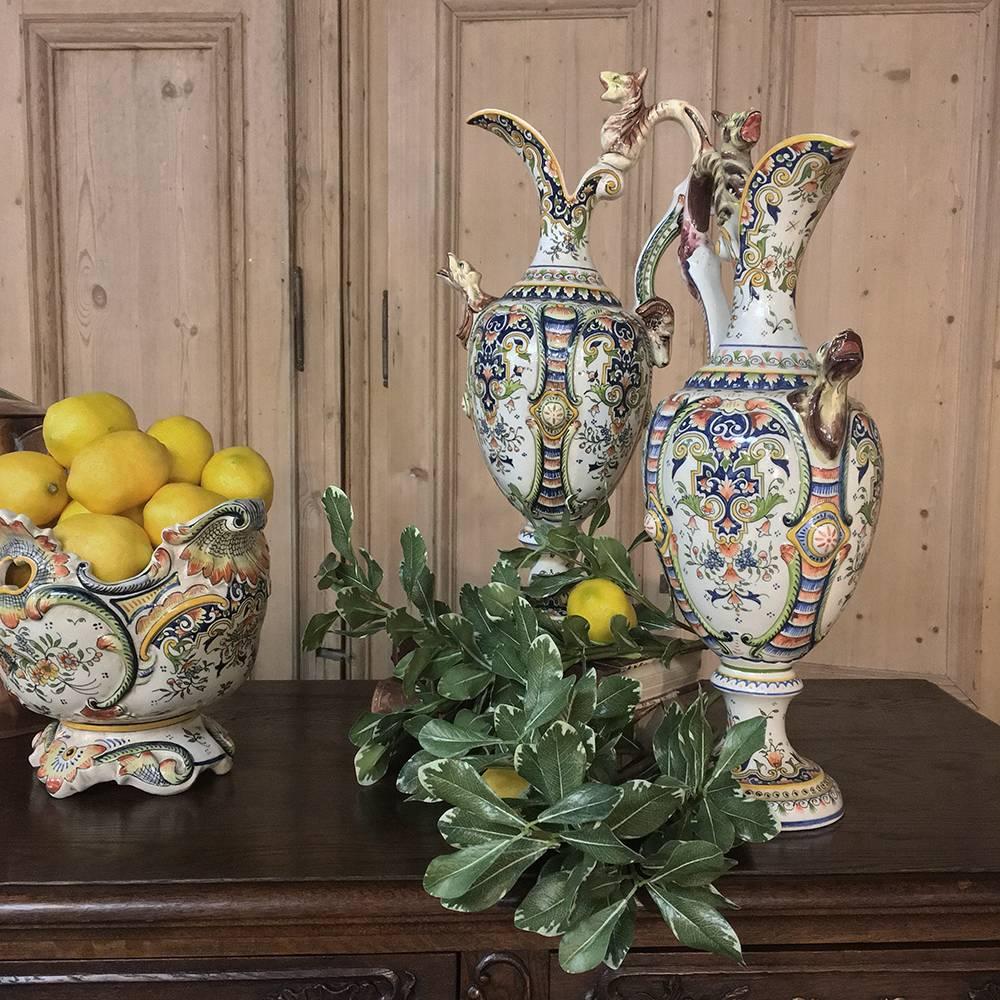 Pair of 19th century hand-painted Ewer vases from Rouen are a spectacular example of the beautiful yet charming artifacts that have come from this region in France for centuries! This pair, purely decorative in nature and by design, feature vivid