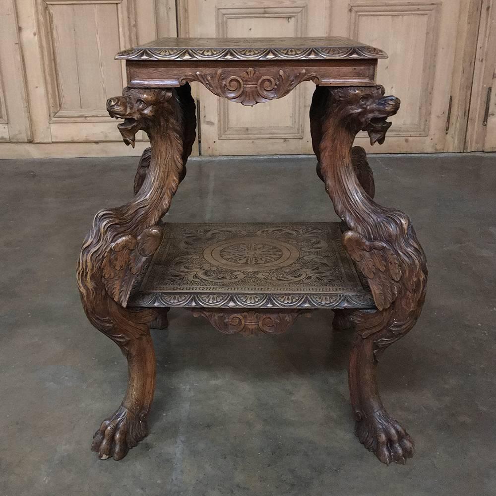 19th century Italian Renaissance walnut end table with dragons was hand-sculpted with amazing artistry and detail! The intaglio carved top is framed by the demilune shell gadrooning on the edge, which is repeated for the lower shelf. A crest with
