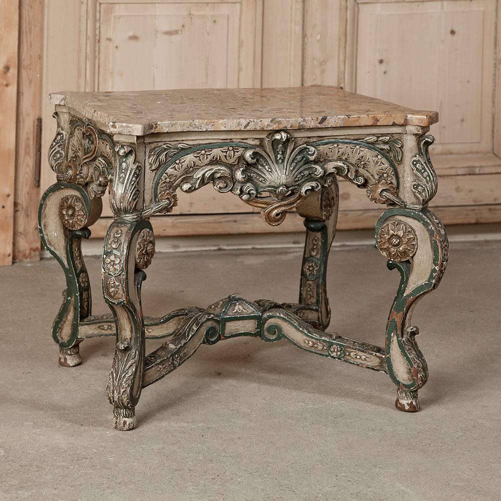 This highly unique Antique Louis XIV End Table features incredibly bold carvings on the framework, apron and exuberantly scrolled legs, and has been topped with Brescia marble with mitered corners. Original multi-hued paint has achieved a stunning