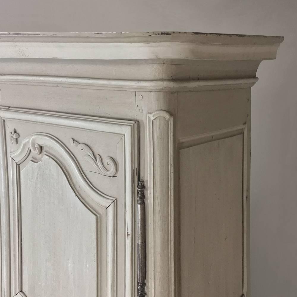 This fine 18th century painted country French armoire is an example of tailored elegance features a lovely two-toned painted finish that has achieved a lovely patina over the past century and a half! Original hand-forged steel hinges and keyguards