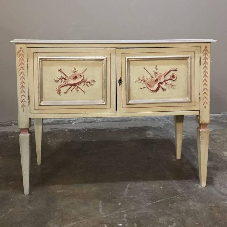 Antique Venetian Hand-Painted Buffet/Commode is the perfect choice for adding a refined neutral color and elegant neoclassical flair, while adding a functional surface and storage.  Musical instruments dominate the themes on all the facades, making