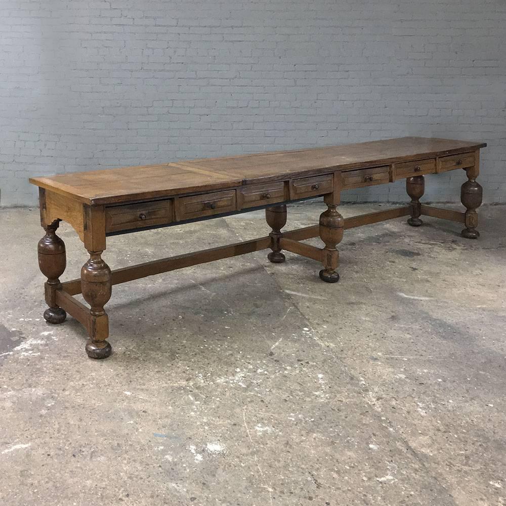 19th century Grand conference table is 12 and a half feet long, yet barely two feet deep making it perfect for a long hallway, a large empty wall, or conference room. Handcrafted from solid old-growth quarter-sawn oak, it features urn legs and seven