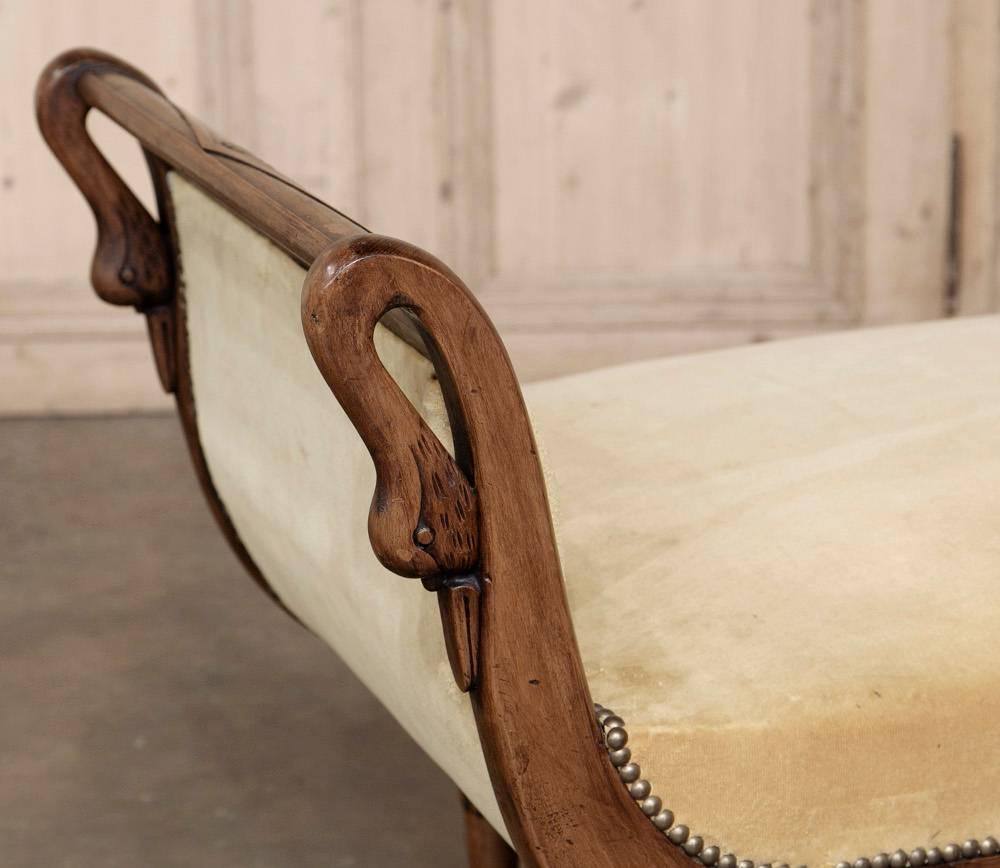 19th century French Directoire style chaise longue with swan carvings was meticulously sculpted from select exotic imported mahogany, chosen for its natural beauty and workability. Mohair upholstery ensures decades of enjoyment, but is easily