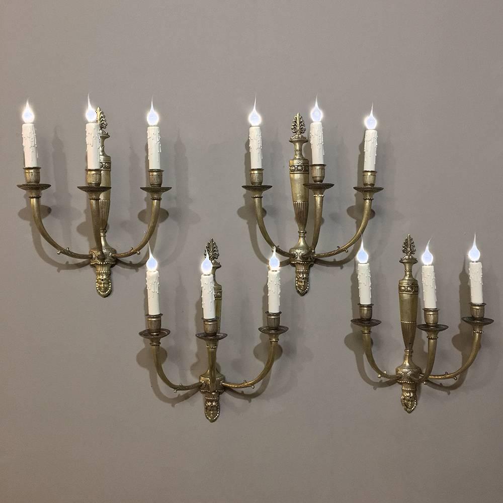 This spectacular set of elegant four antique French Empire Bronze Wall Sconces are perfect for a staircase, bath, hallway, or anywhere a set of four works, each sconce depicts a Grecian urn in the form of an Amphora, designed thousands of years ago.