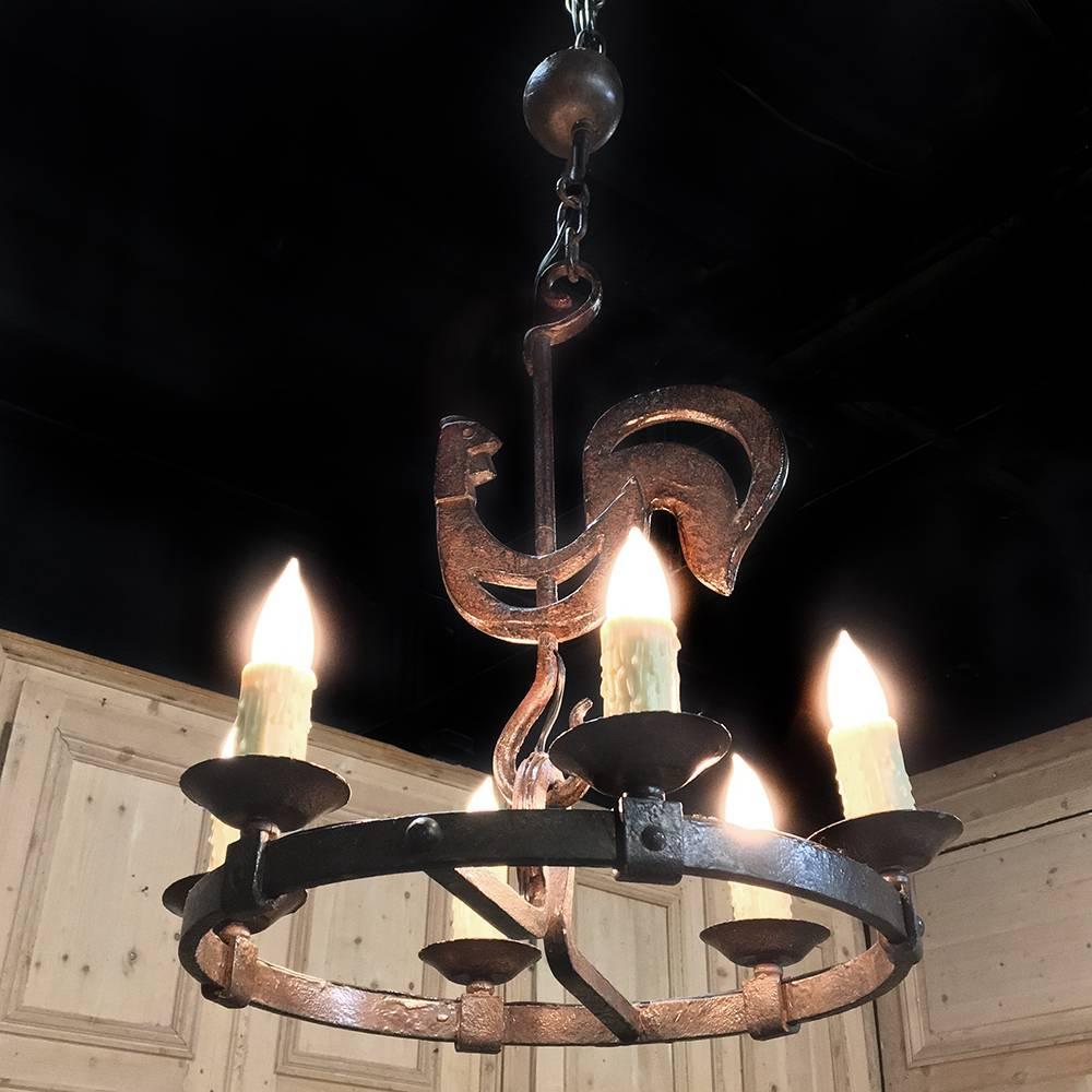 Forged by hand from red-hot iron, this charming Country French wrought iron chandelier features a charming stylized rooster as its central visual element. Rustic lines make this the ideal choice for a casual decor! It has already been wired and