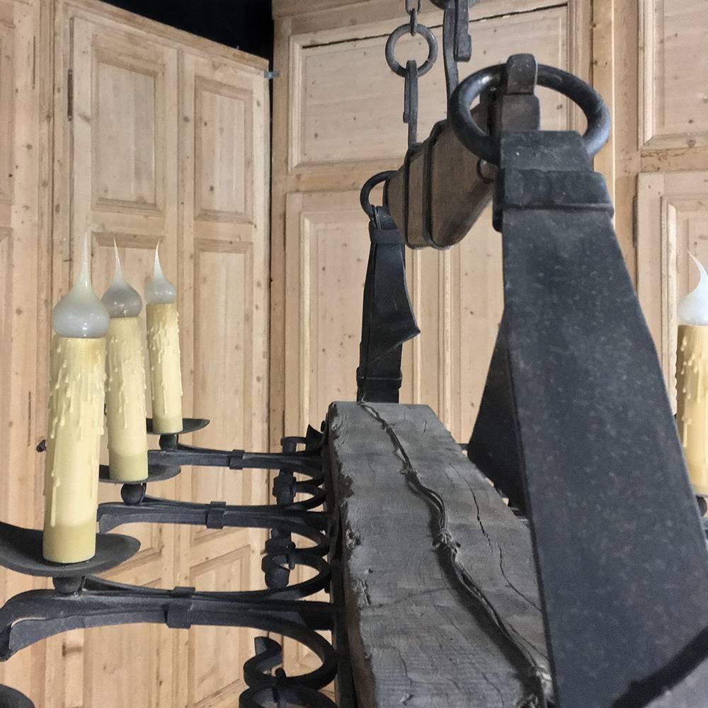 Antique wrought iron and beam chandelier features iron hand-forged to appear amazingly realistically like leather straps and buckles! This intriguing design obviously is the result of an extraordinarily talented blacksmith, with the iron elements