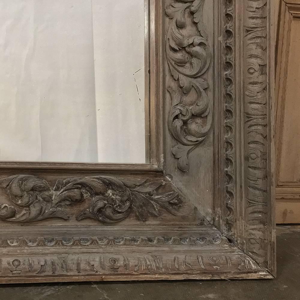 19th century grand hand-carved Renaissance stripped oak mirror was crafted on an oversized scale for a large manoir in the north of France. The patina of the wood is striking when it has been adorned by a master woodcarver in the Renaissance style,