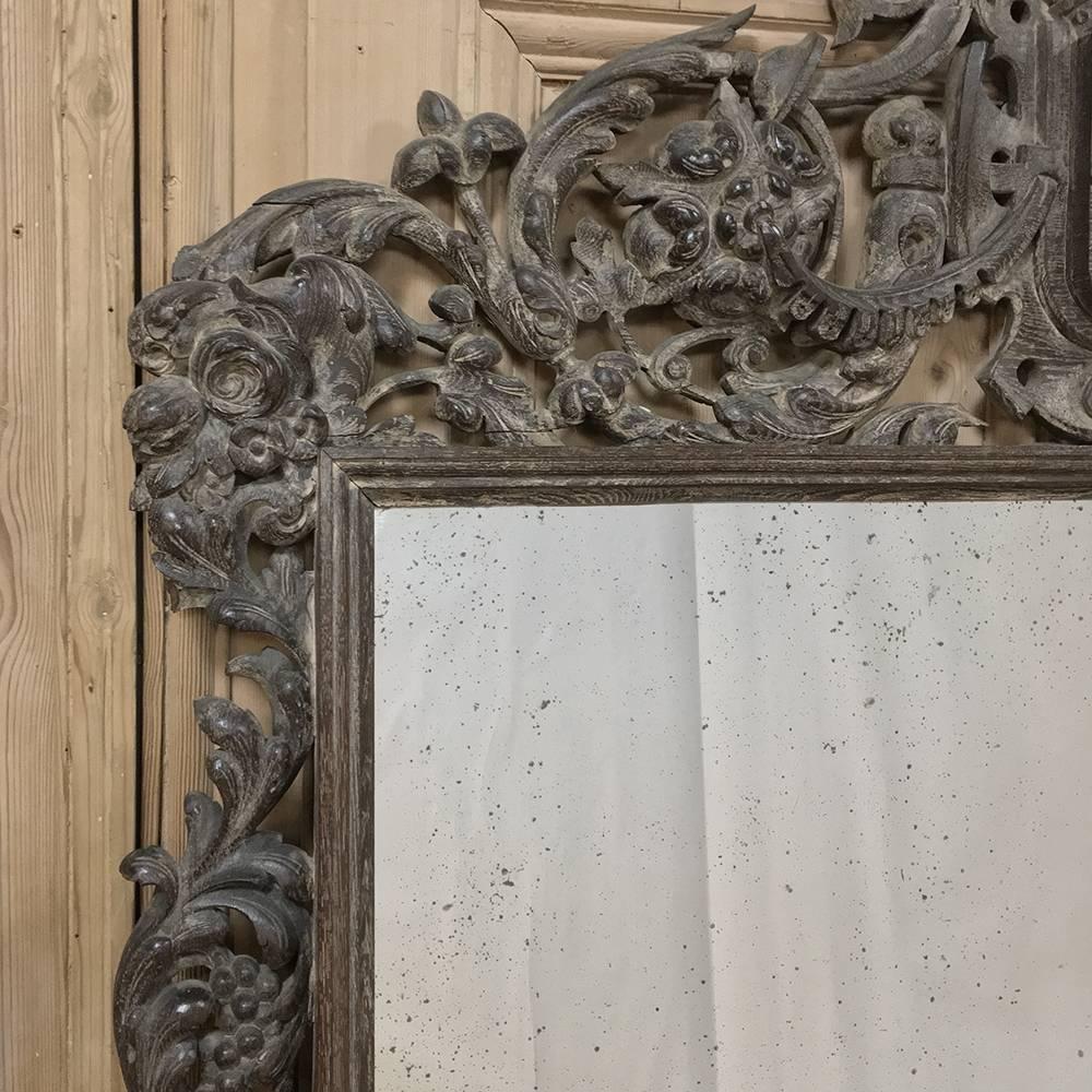 Grand 19th century French Renaissance Revival carved and stripped oak mirror was crafted for a grand Schloss in northern Germany, and features its original silvering which has developed a wonderful distressed patina over the past century and a half.